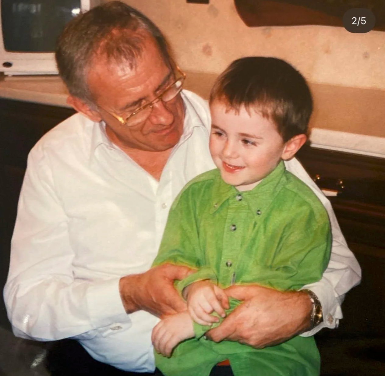 A family photograph of a grandfather holding his young grandchild
